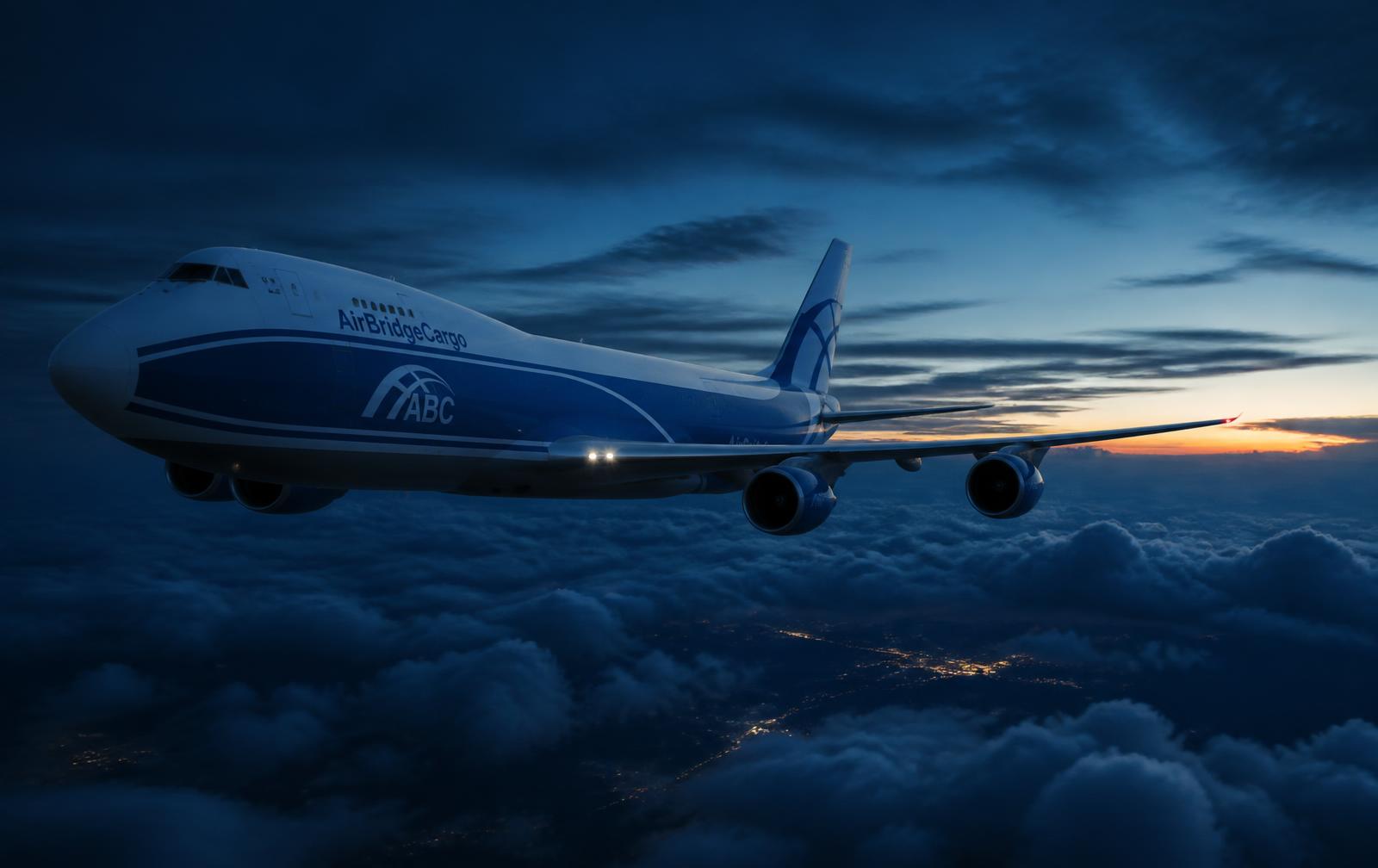 Cargo aircraft flying above the clouds at dusk